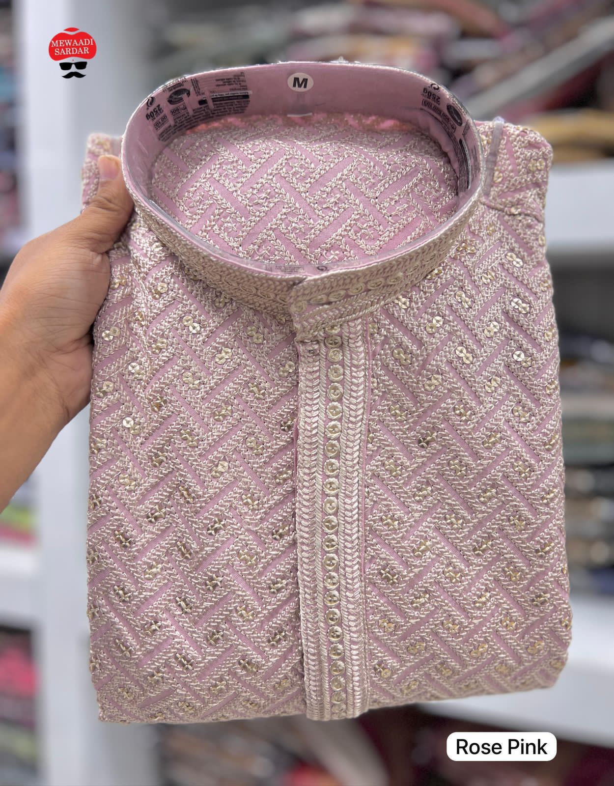 Baby Pink fabric swatch held by a hand with blurred store background