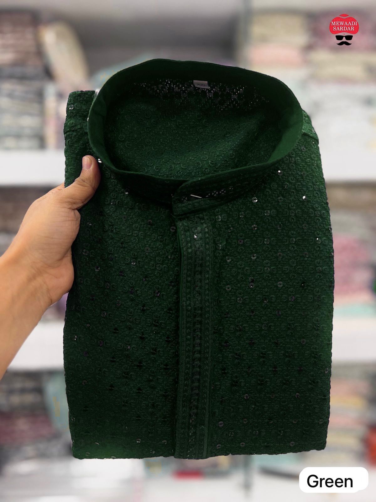 Dark Green fabric held by a hand with a blurred background