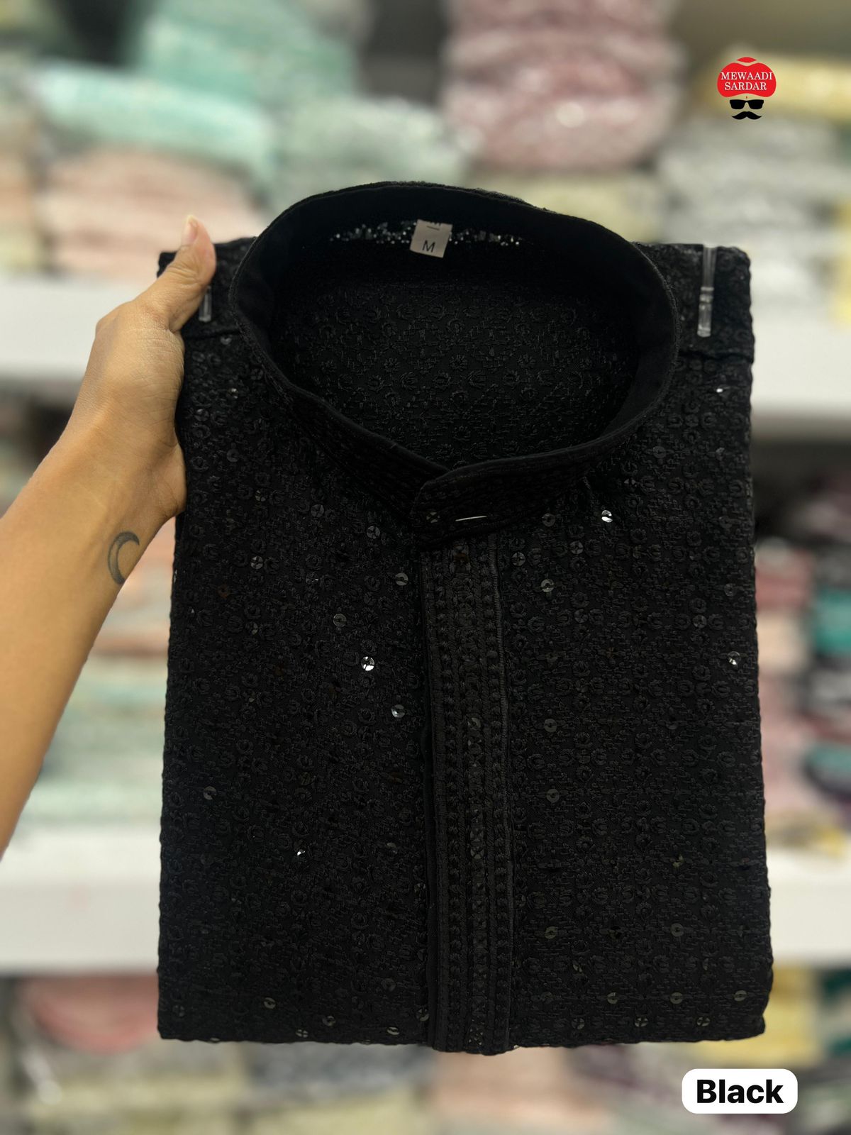 Black textured bag held by a hand with a blurred store background