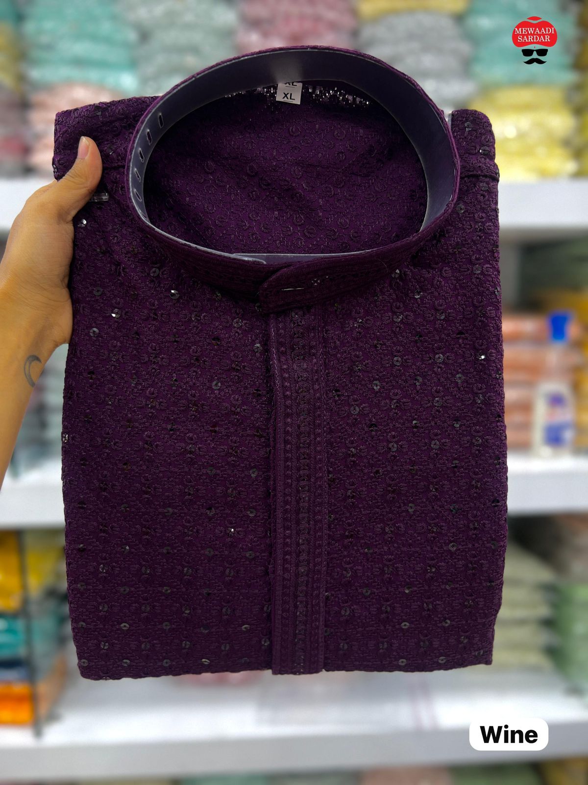 Wine shirt held up against a blurred store shelf background