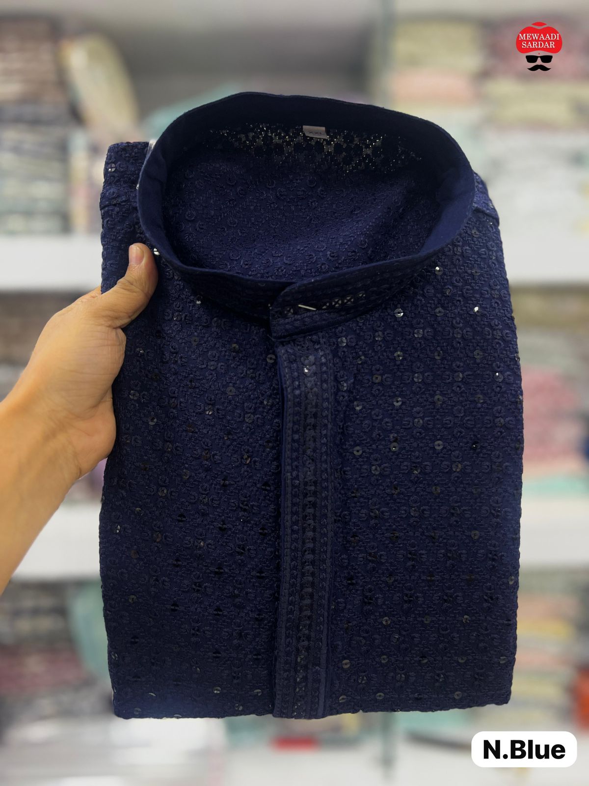 Navy blue textured fabric held by a hand with a blurred background
