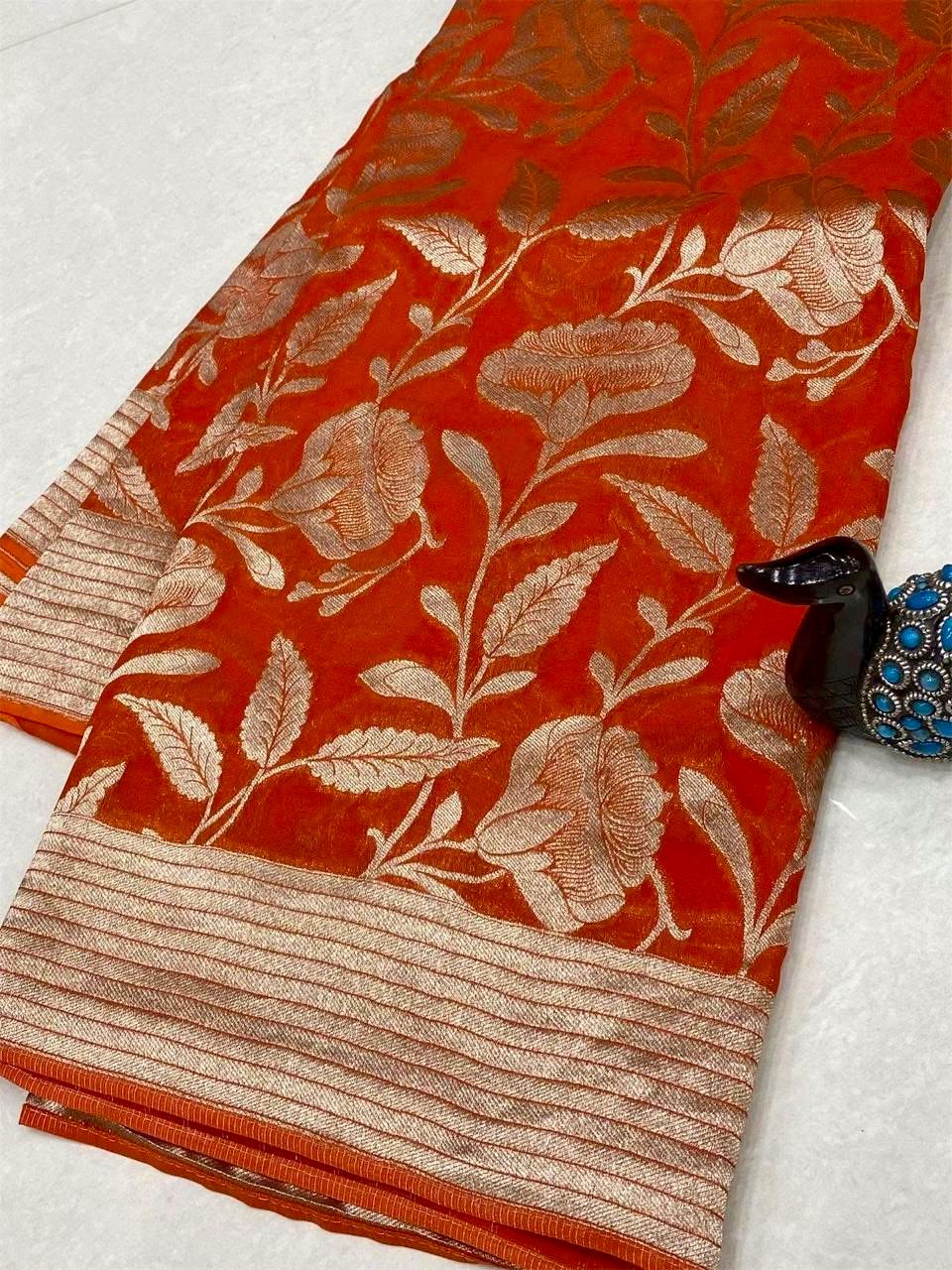 Orange saree with floral patterns on a white background