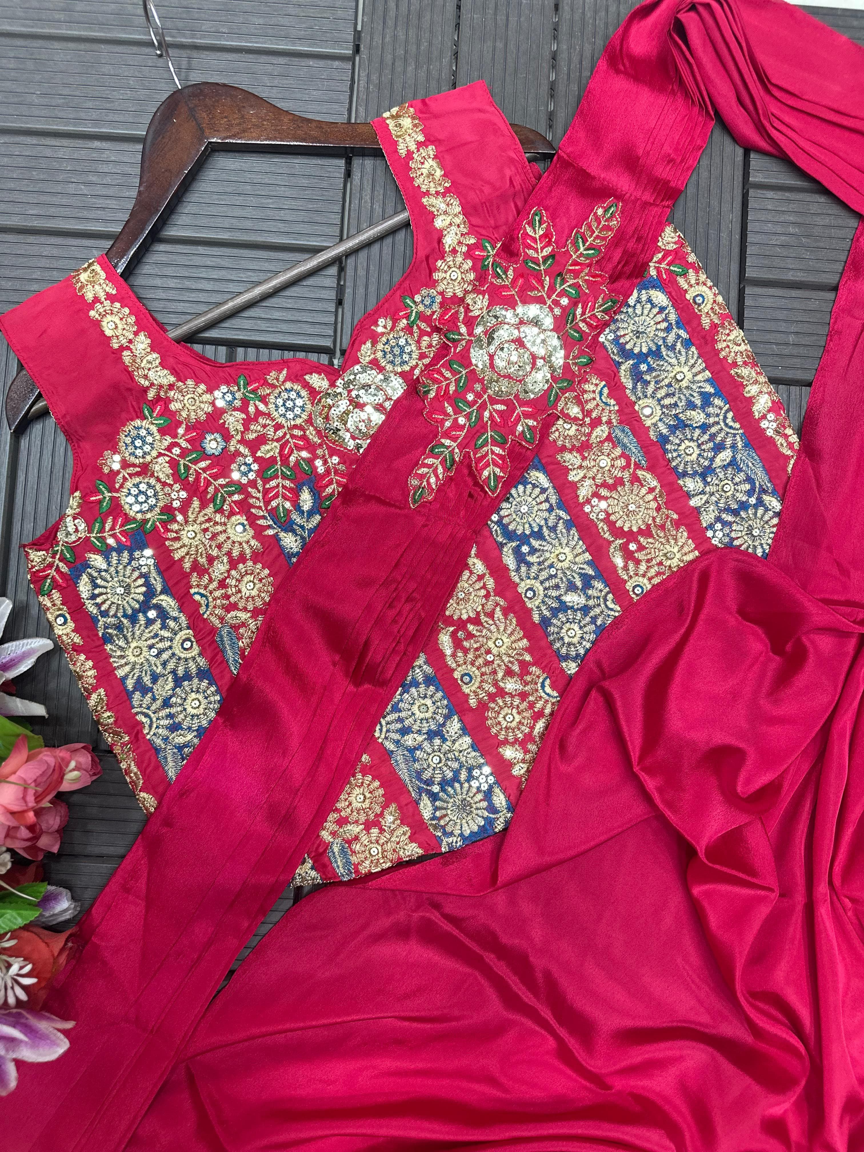 Pink traditional outfit with floral embroidery on a hanger against a dark background