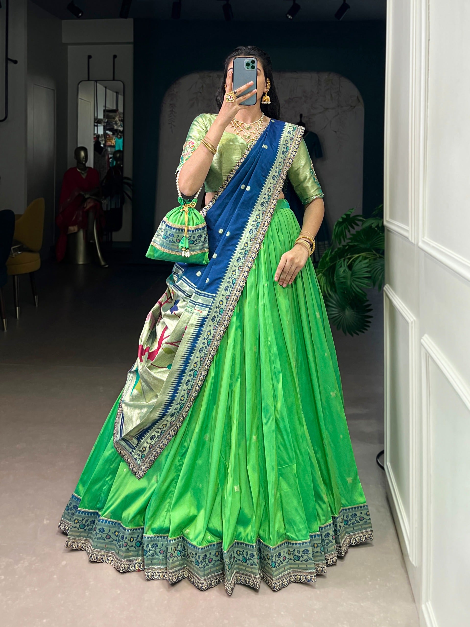 Parrot Green saree with blue border in a room setting.