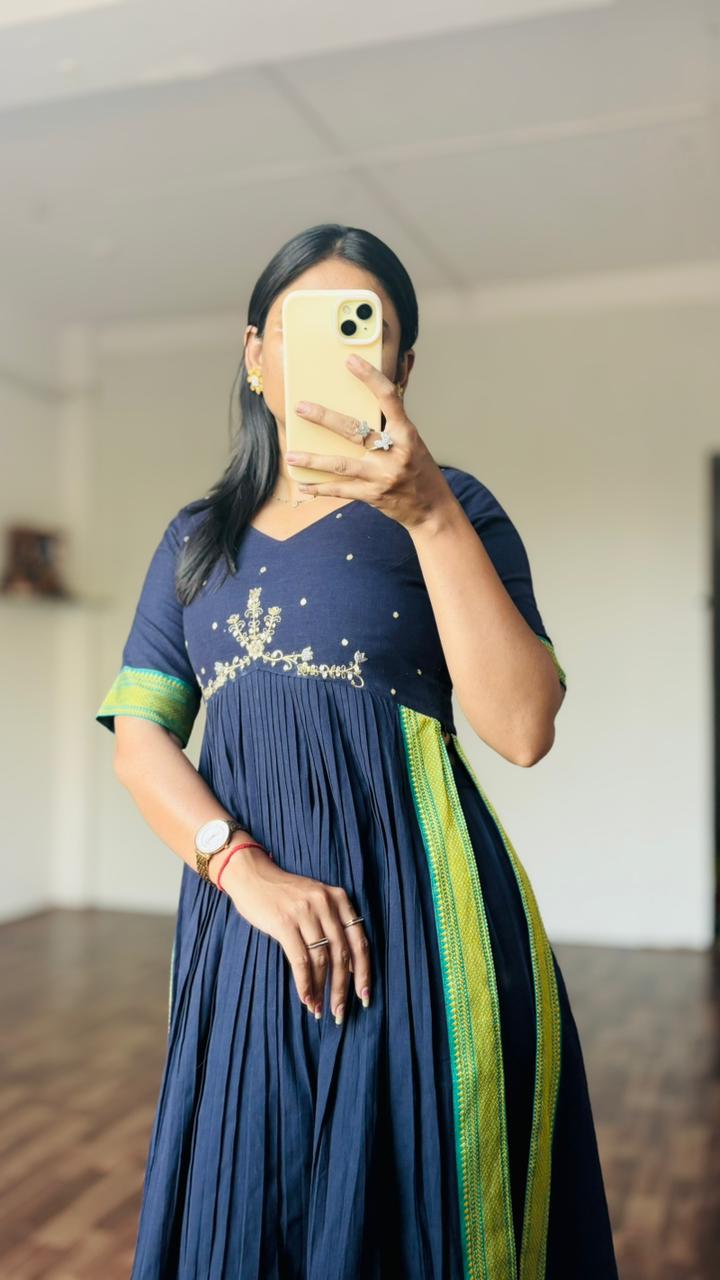 Person wearing a Navy blue dress with green accents, taking a mirror selfie