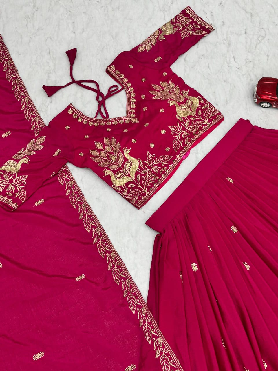 Pink traditional outfit with gold embroidery on a white background