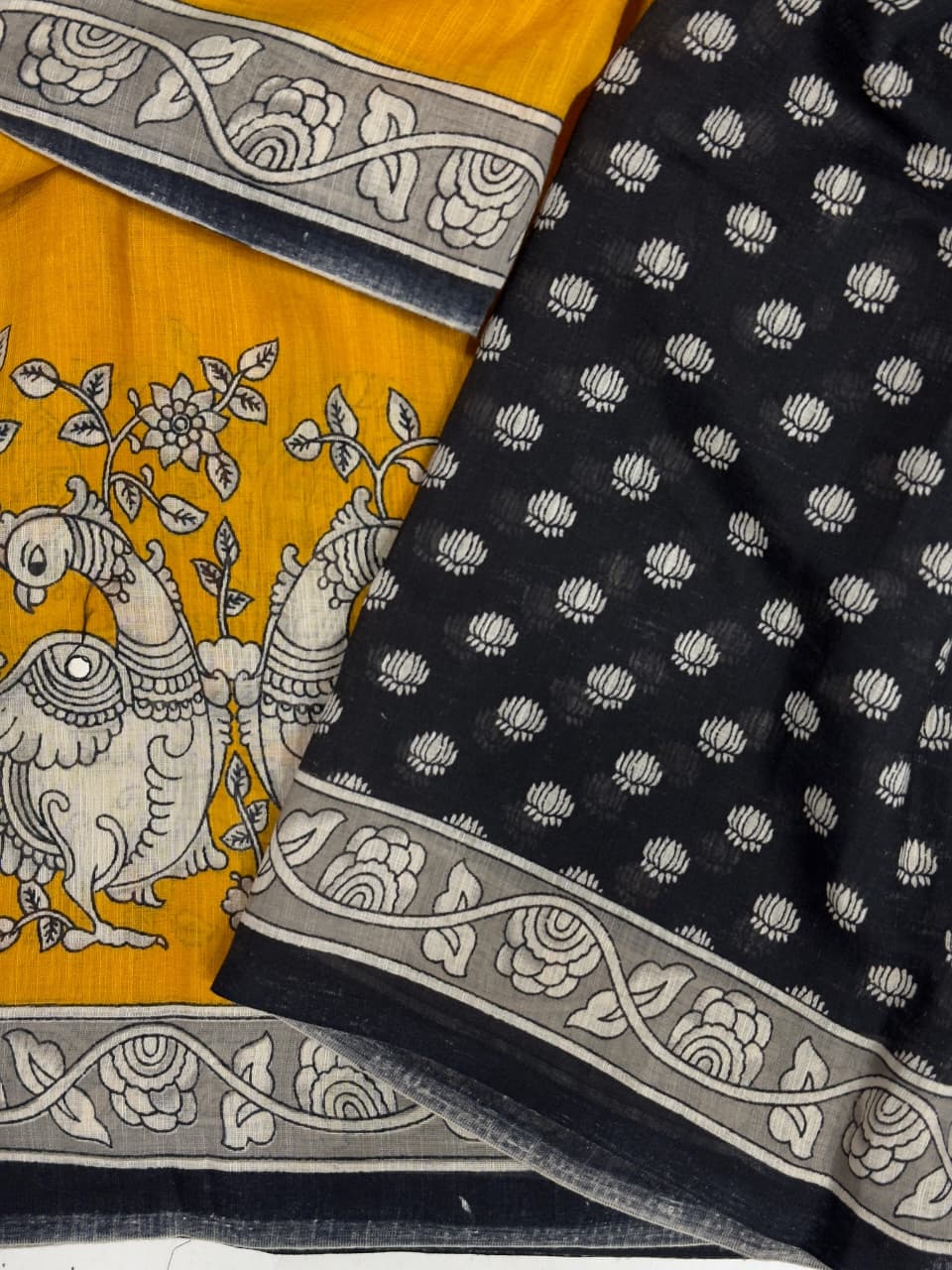 Two pieces of fabric with intricate patterns, one yellow and one black, on a white background.