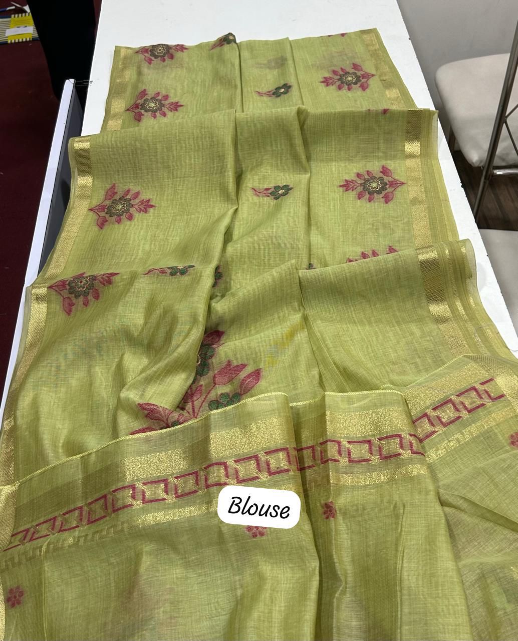 Olive Green saree with floral patterns on a white surface