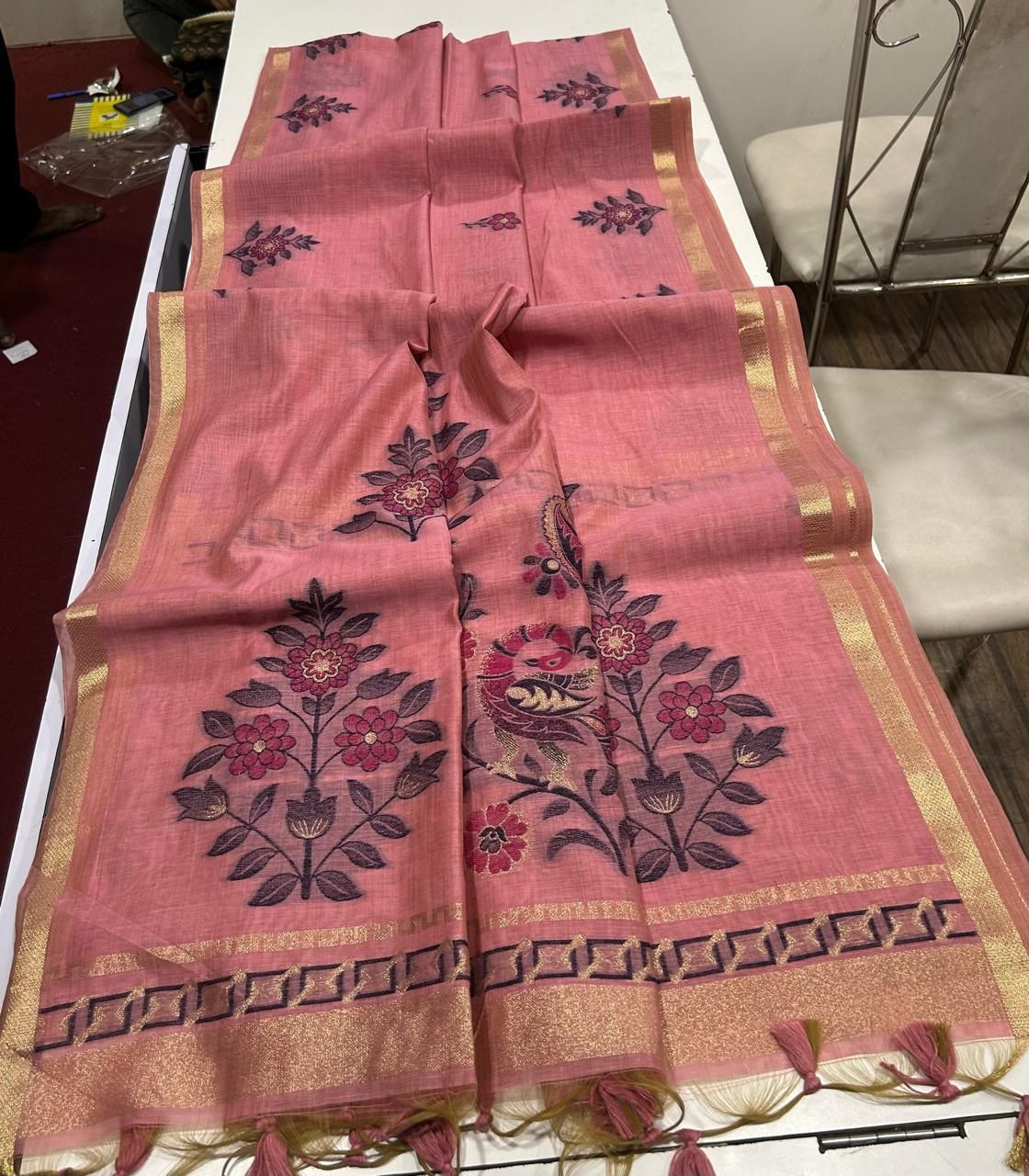 Light Pink saree with floral patterns on a white table
