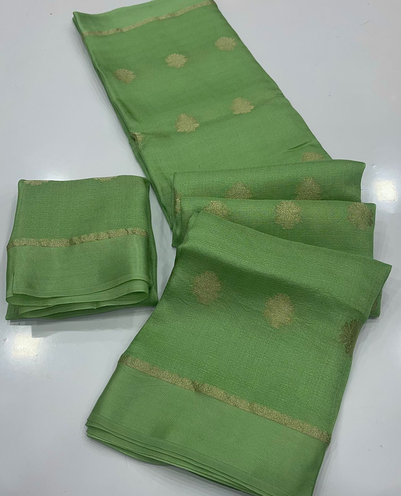 Light Green fabric with gold patterns on a white background