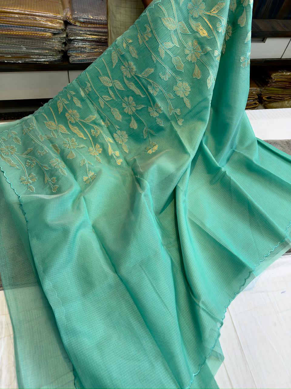 Turquoise Blue fabric with gold floral patterns on a surface
