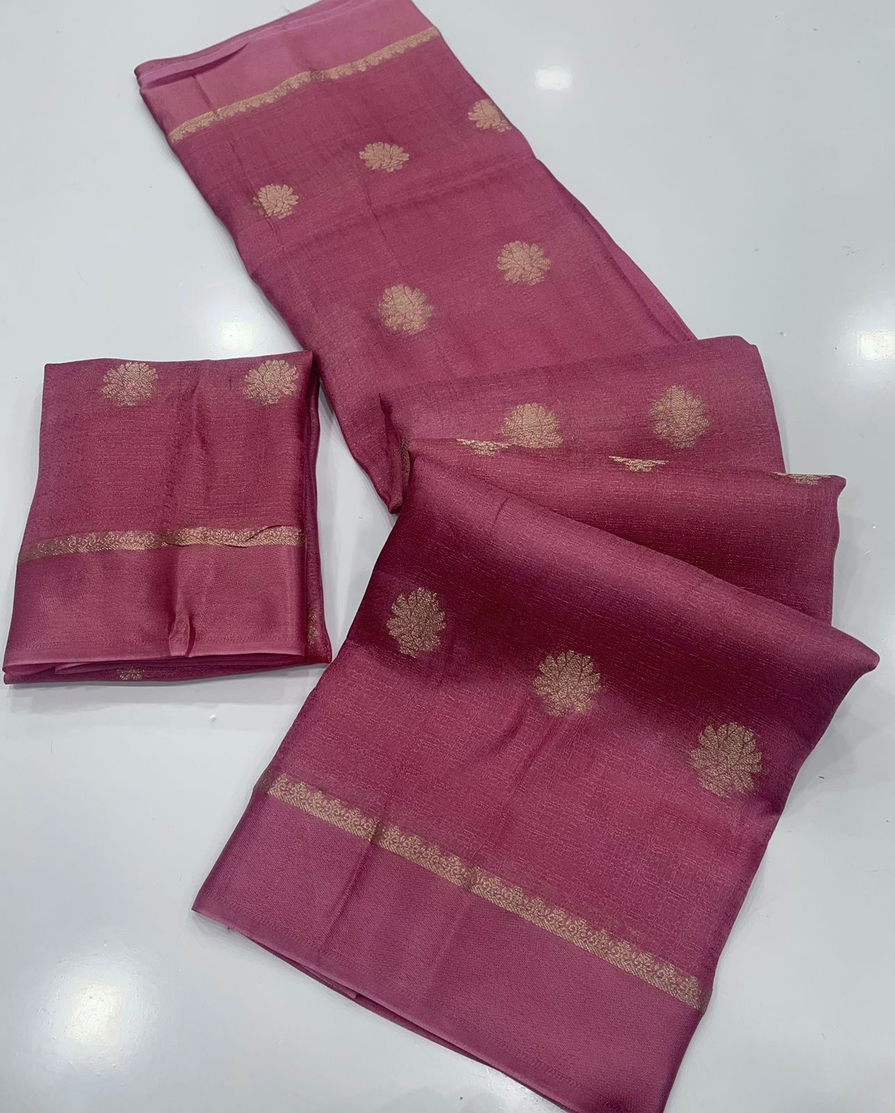 Onion pink saree with gold patterns on a white background