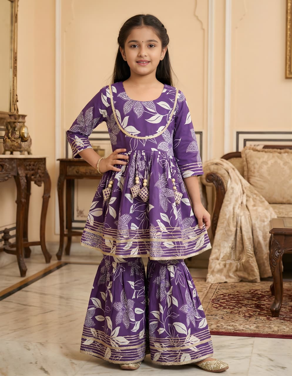 Young girl in a Lavender traditional outfit standing in an elegant room.