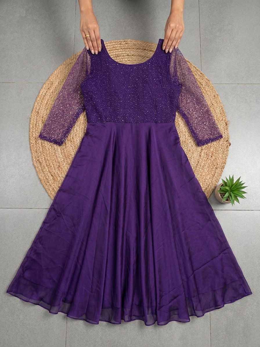 Purple dress with sheer sleeves on a gray floor.