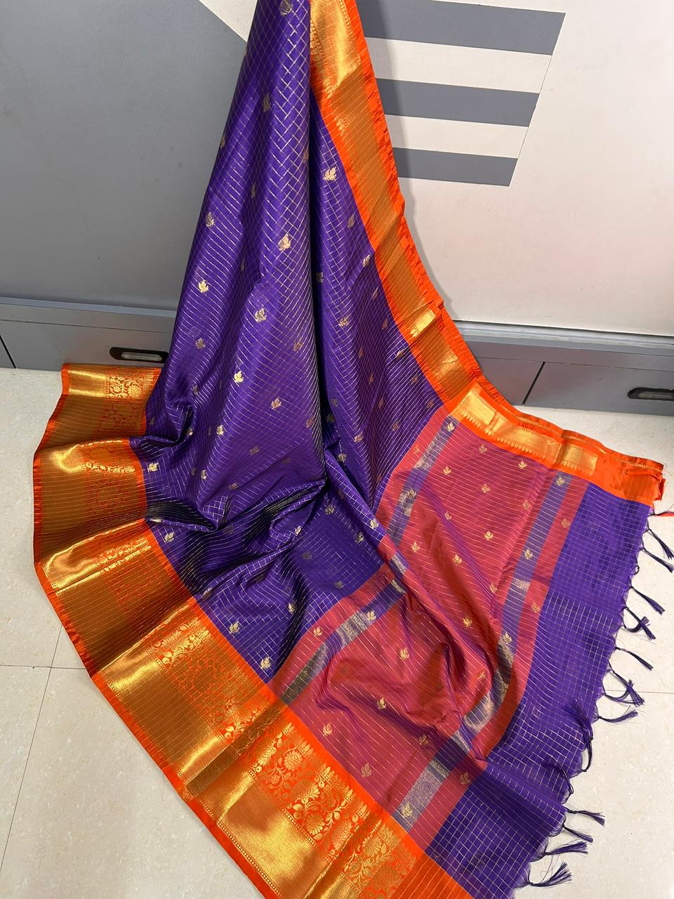 Purple and orange saree with a pattern on a white surface