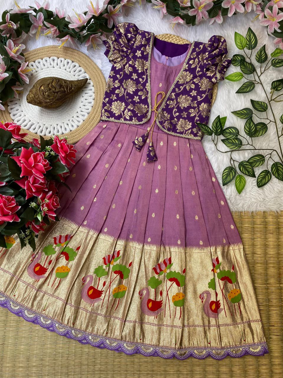 Traditional outfit with purple and embroidered dress on a decorative background with flowers and leaves.