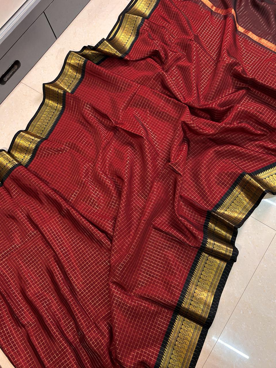 Red saree with gold border on a light-colored floor