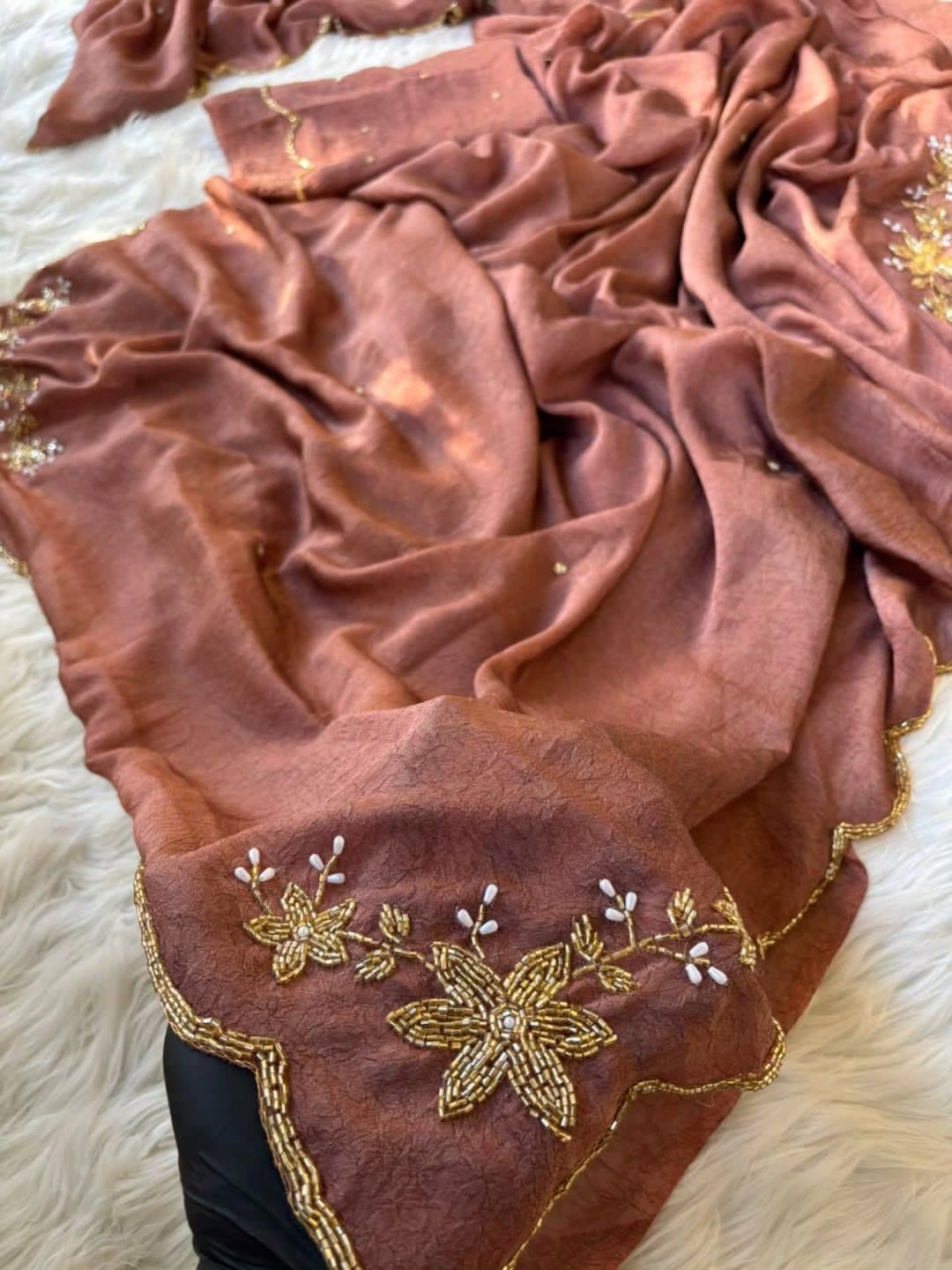 Brown fabric with gold embroidery on a textured surface