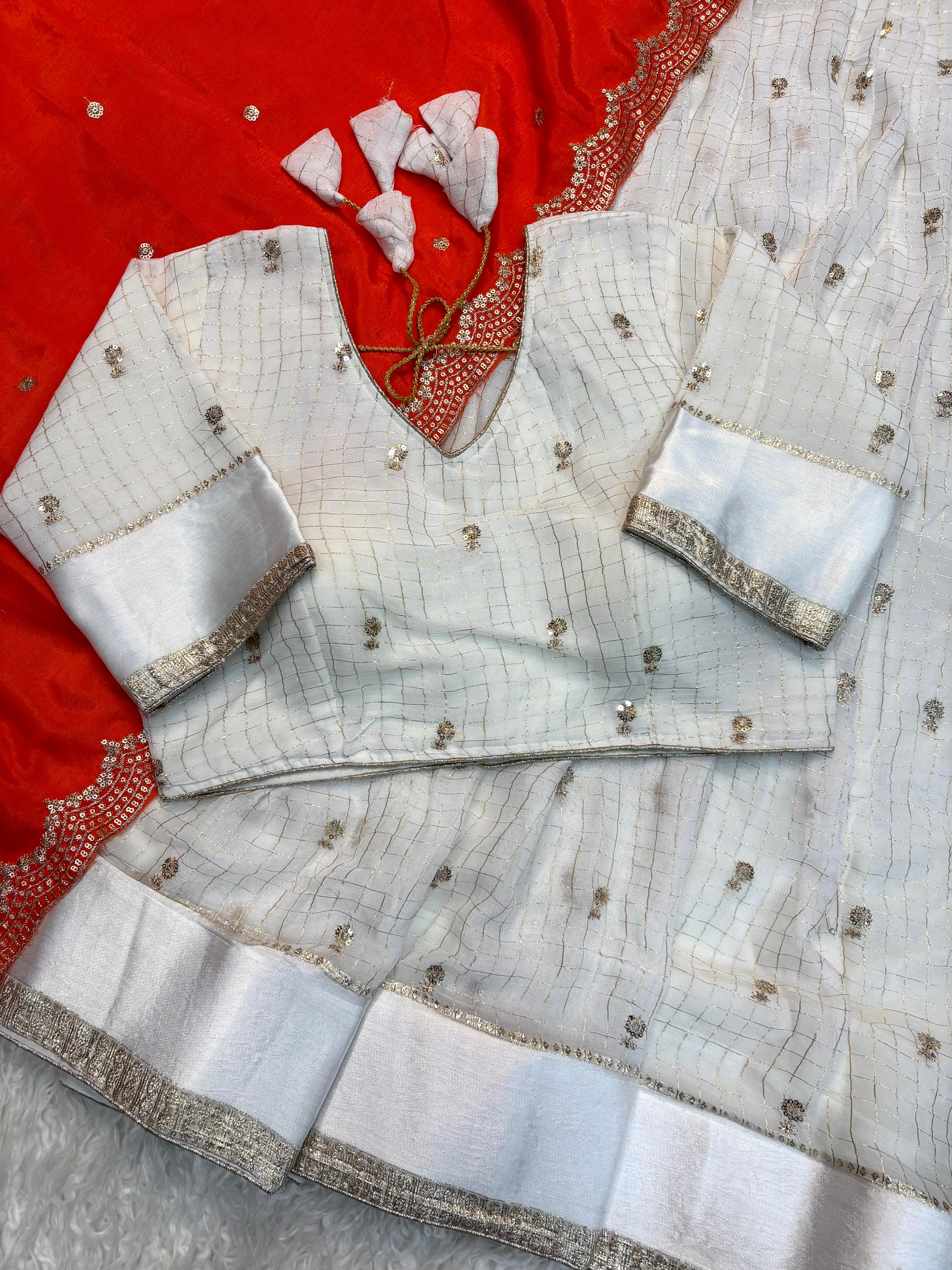 White embroiderey blouse with orange saree in the background