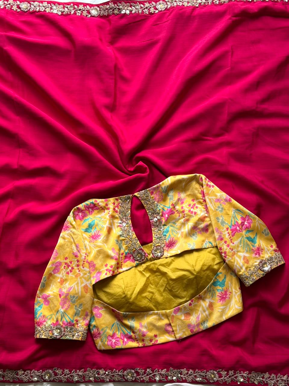 Yellow floral blouse with gold details on a pink fabric background