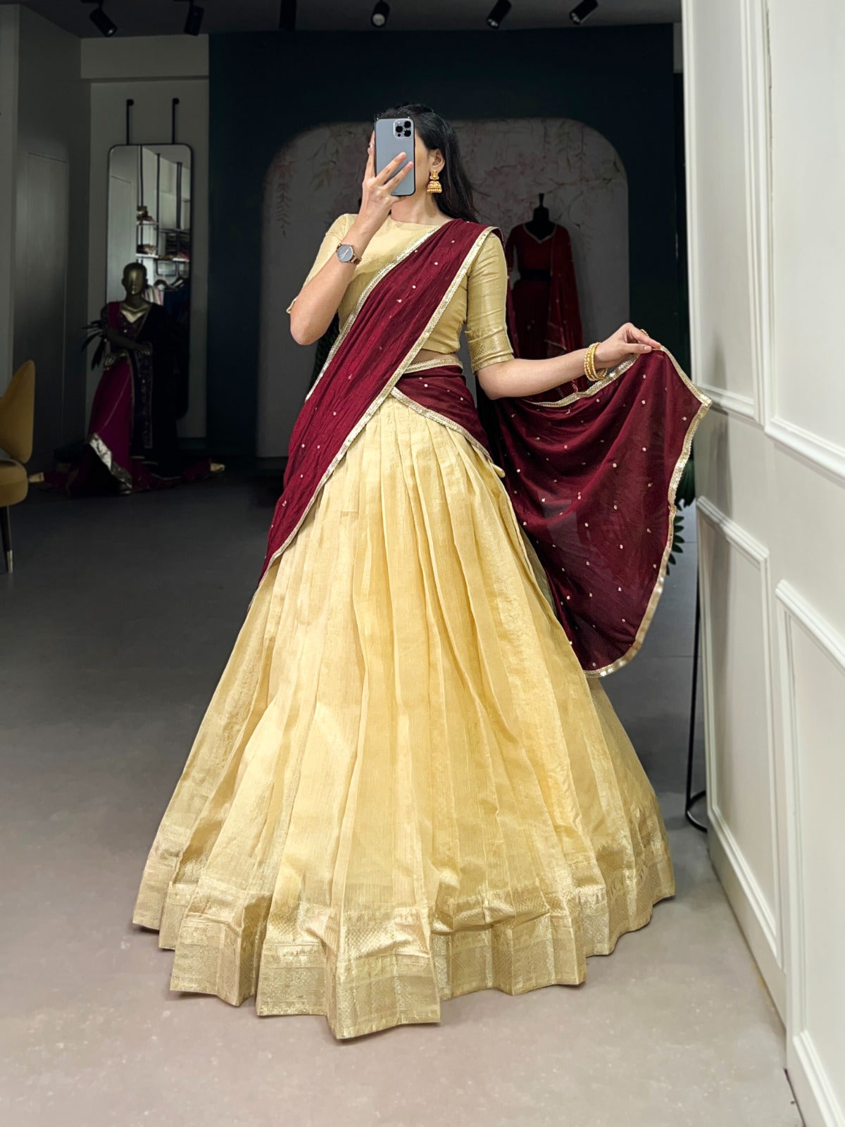 Beige saree with a blouse in a room.