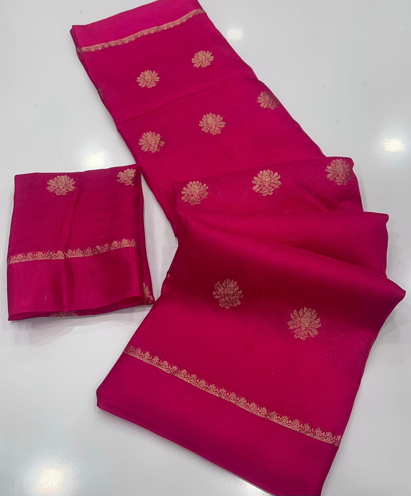 Rani Pink saree with gold embroidery on a white background