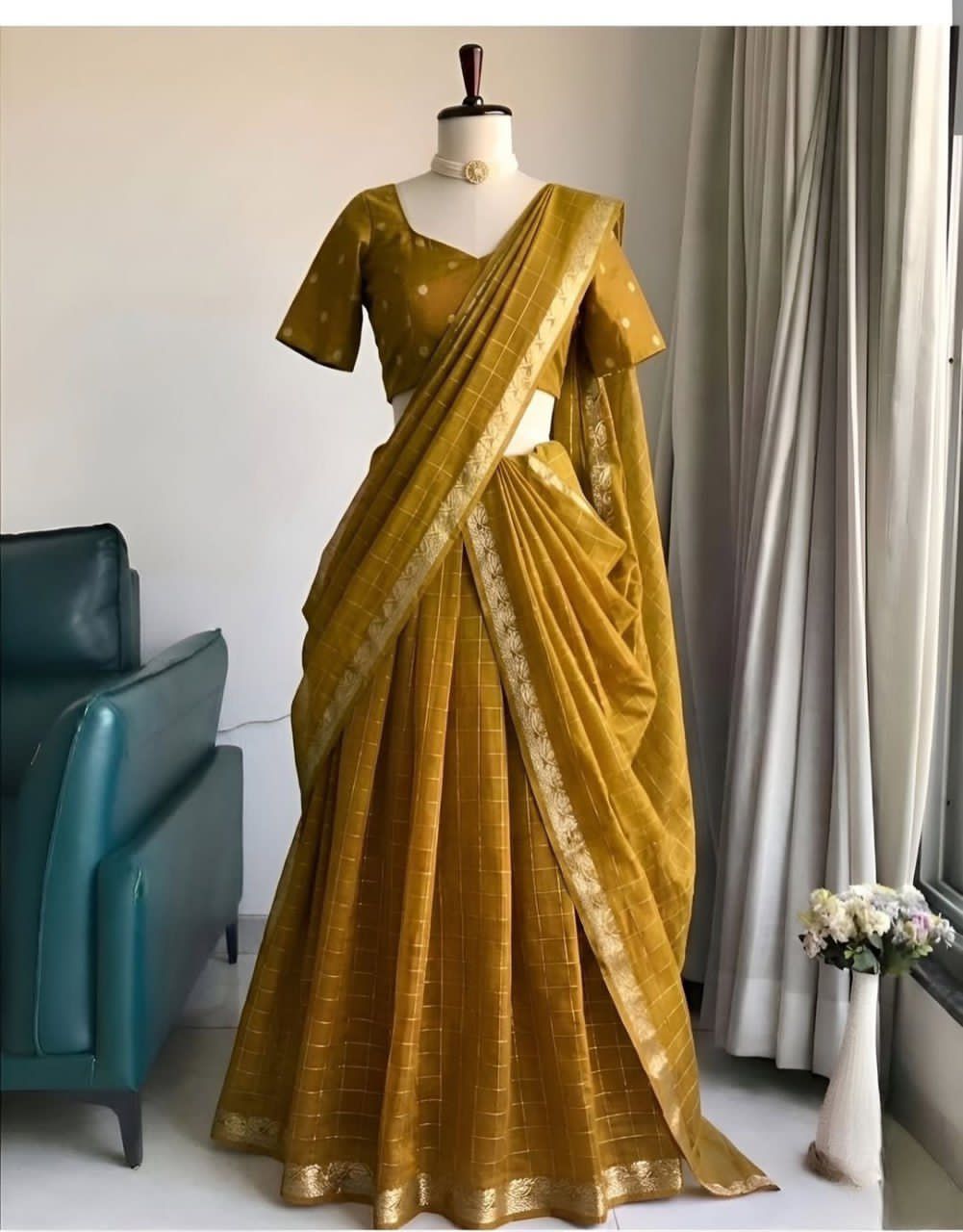 Mustard yellow saree on a mannequin against a neutral background