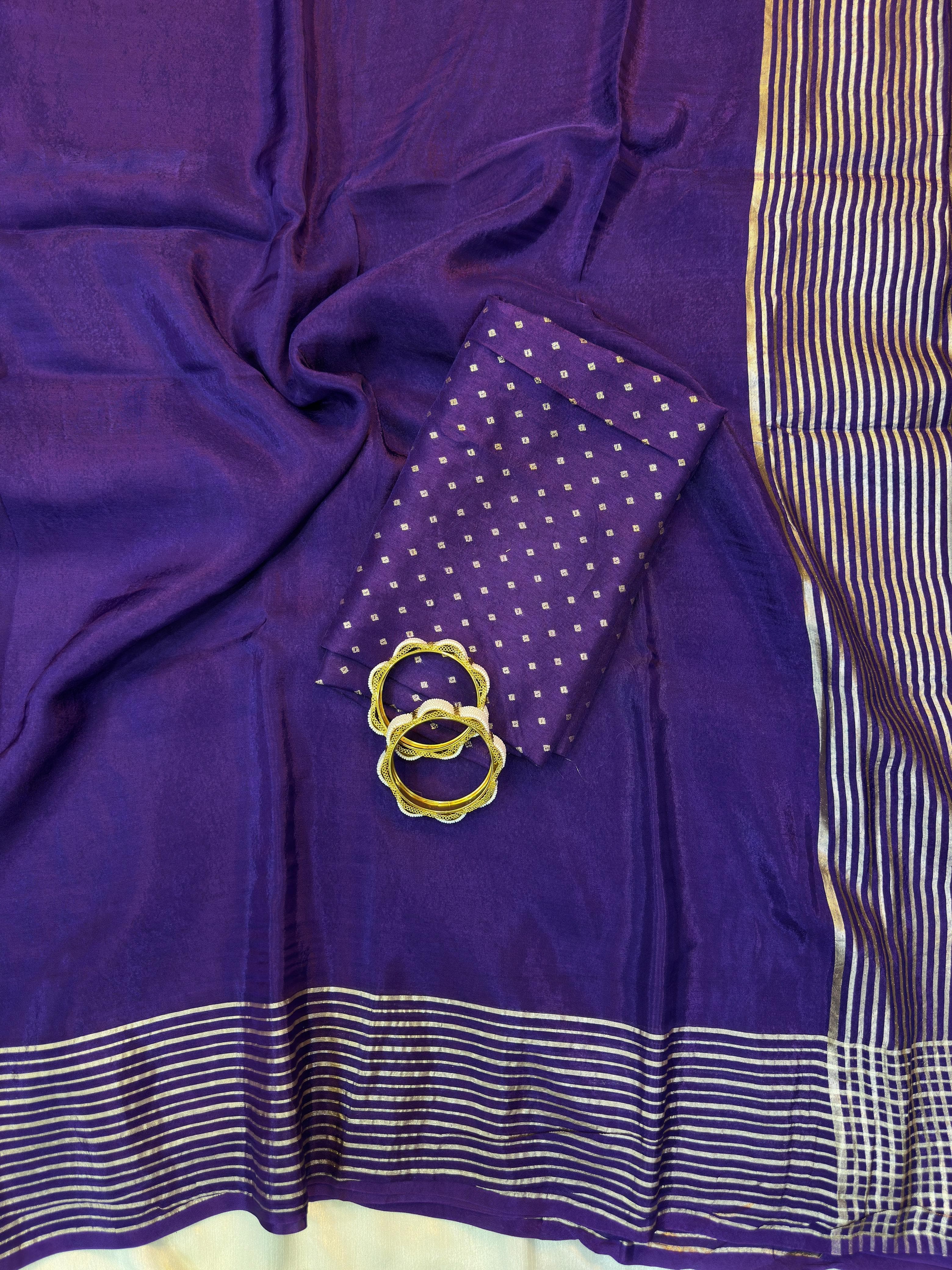 Purple fabric with a small pouch and gold ring on a white background