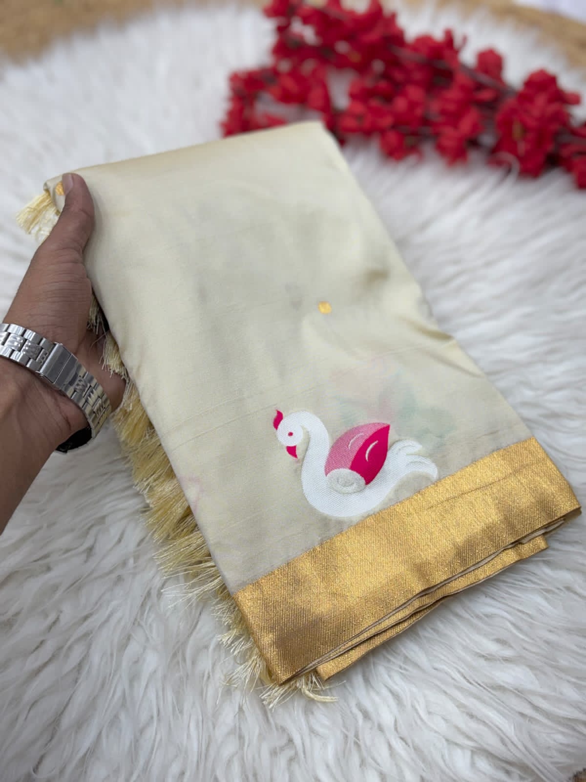 White fabric with a swan design held by a hand on a white surface