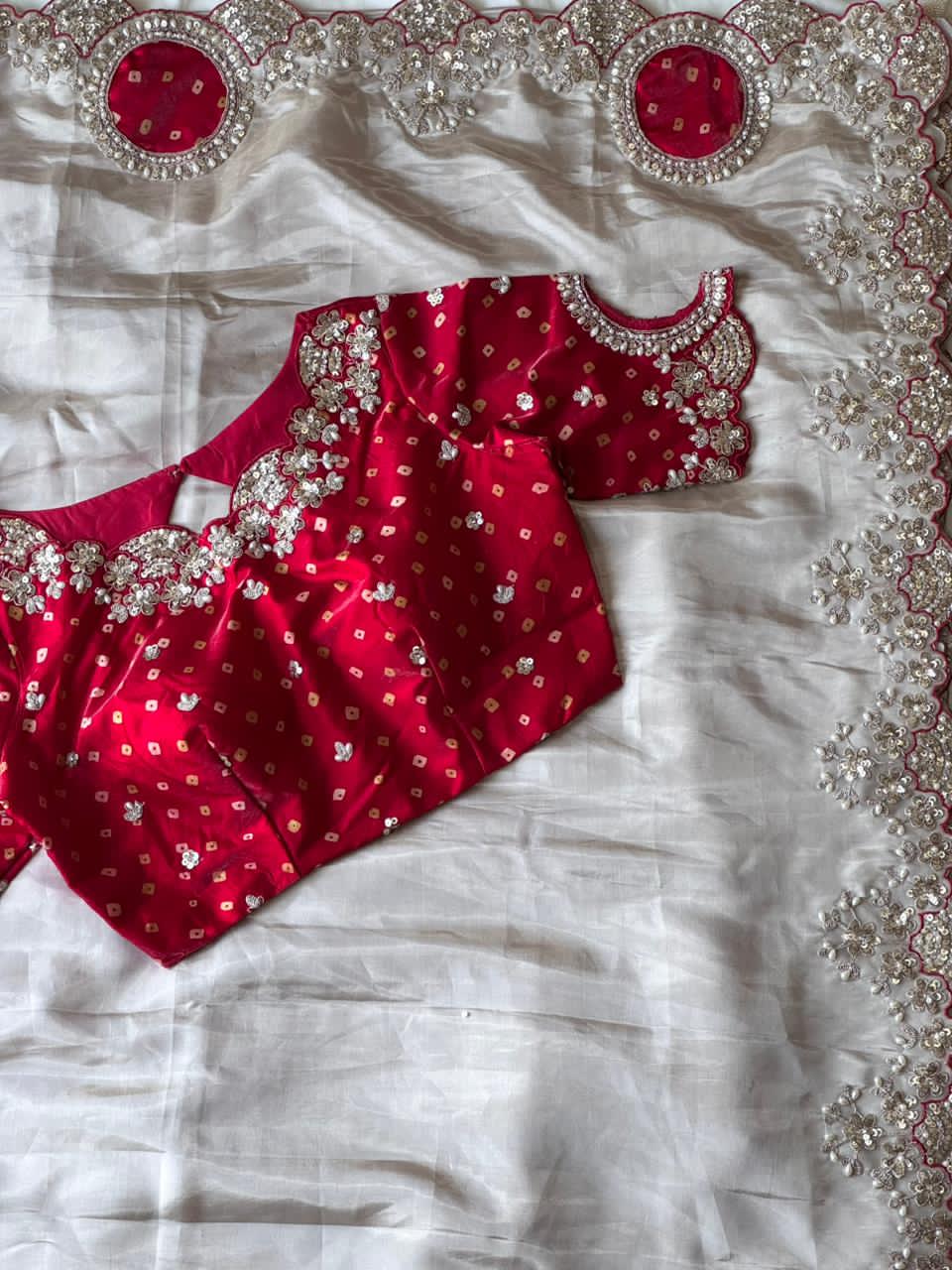 Red blouse with silver embroidery on a white fabric background