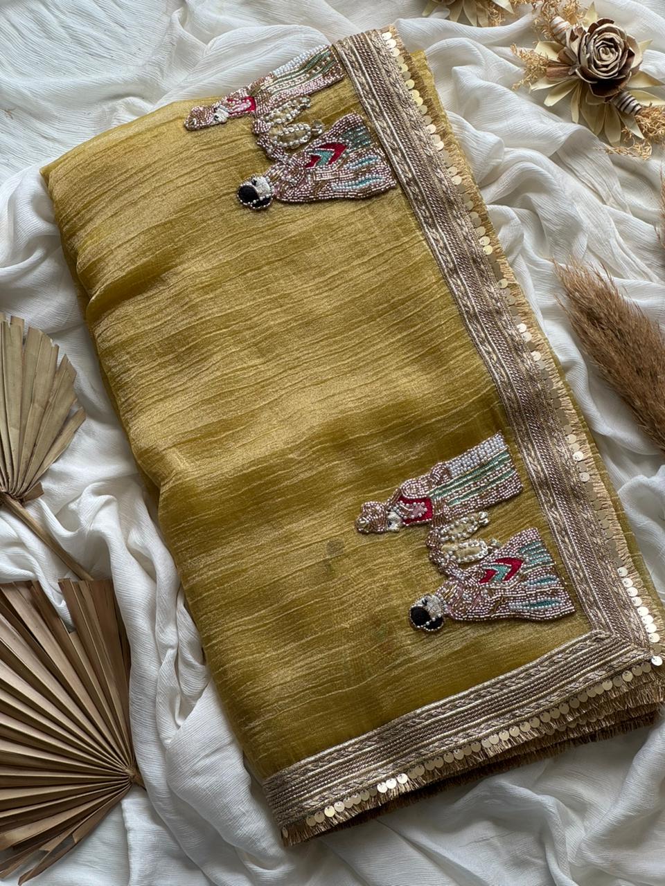 Light yellow saree with intricate patterns on a white fabric background