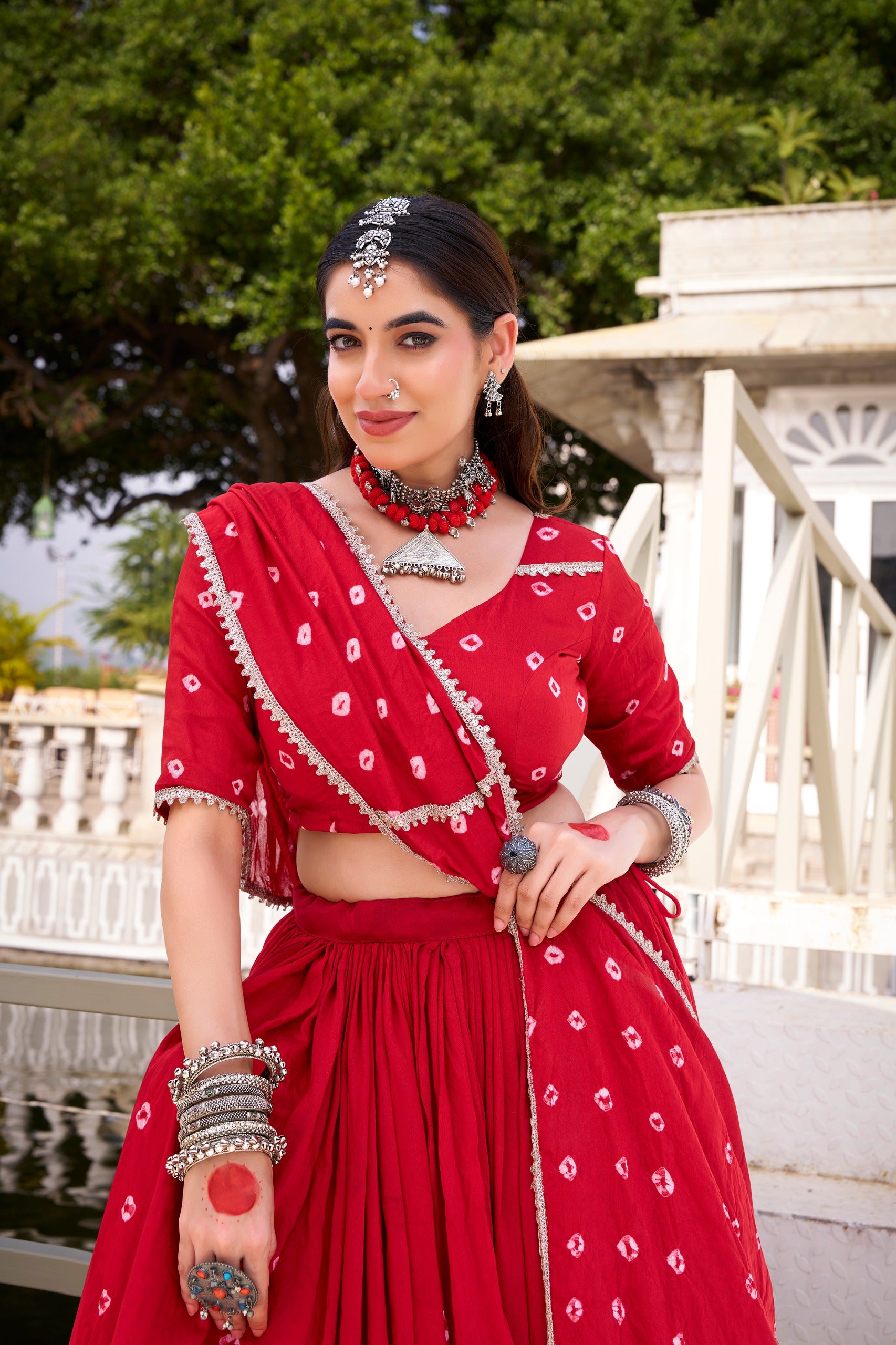 Woman in a red traditional outfit with jewelry outdoors