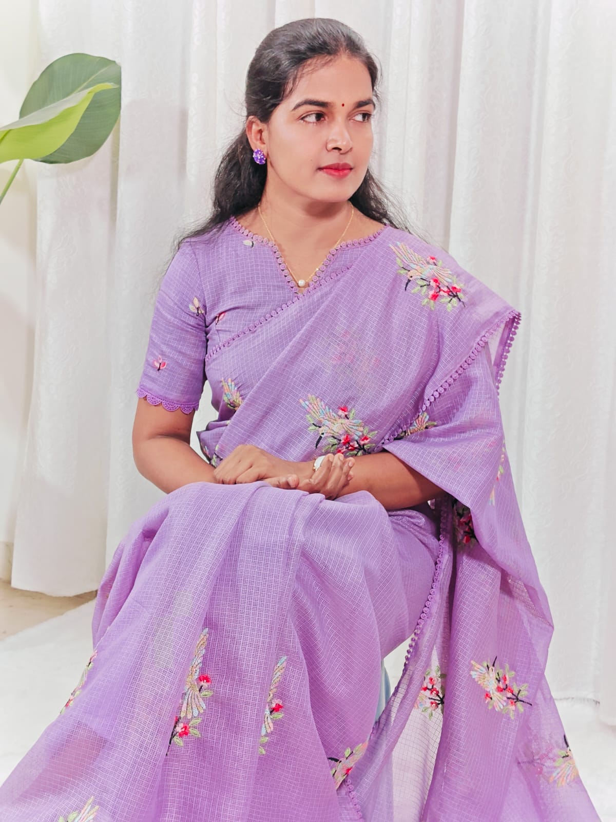 Woman wearing a lavender saree with floral embroidery 