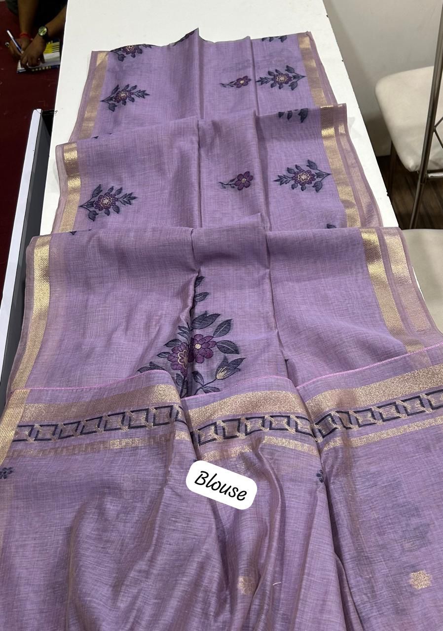 Purple blouse with floral embroidery on a white surface