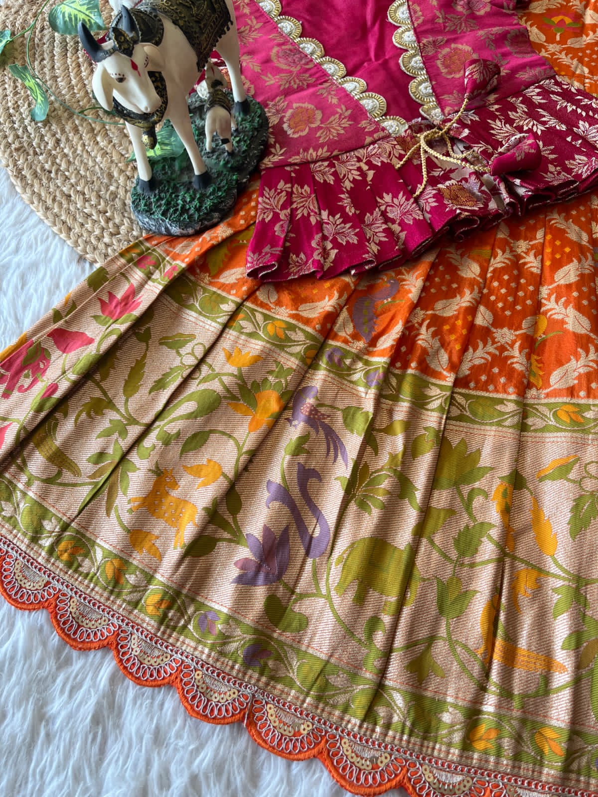 Colorful orange traditional fabric with floral patterns on a texture surface