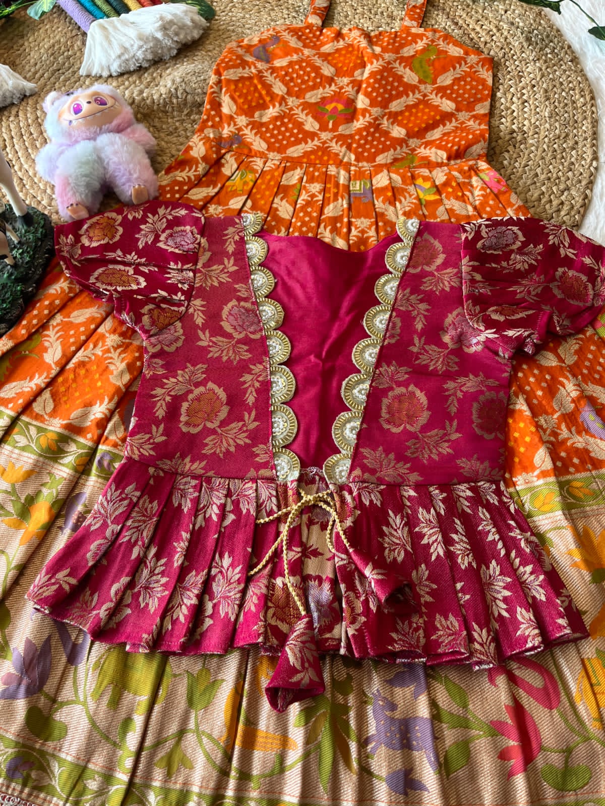 Colorful orange traditional outfits with a blouse and pattern on a texture surface
