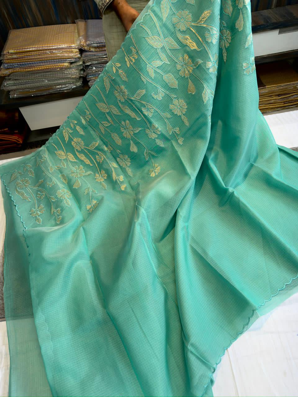 Turquoise Blue fabric with gold embroidery on a surface