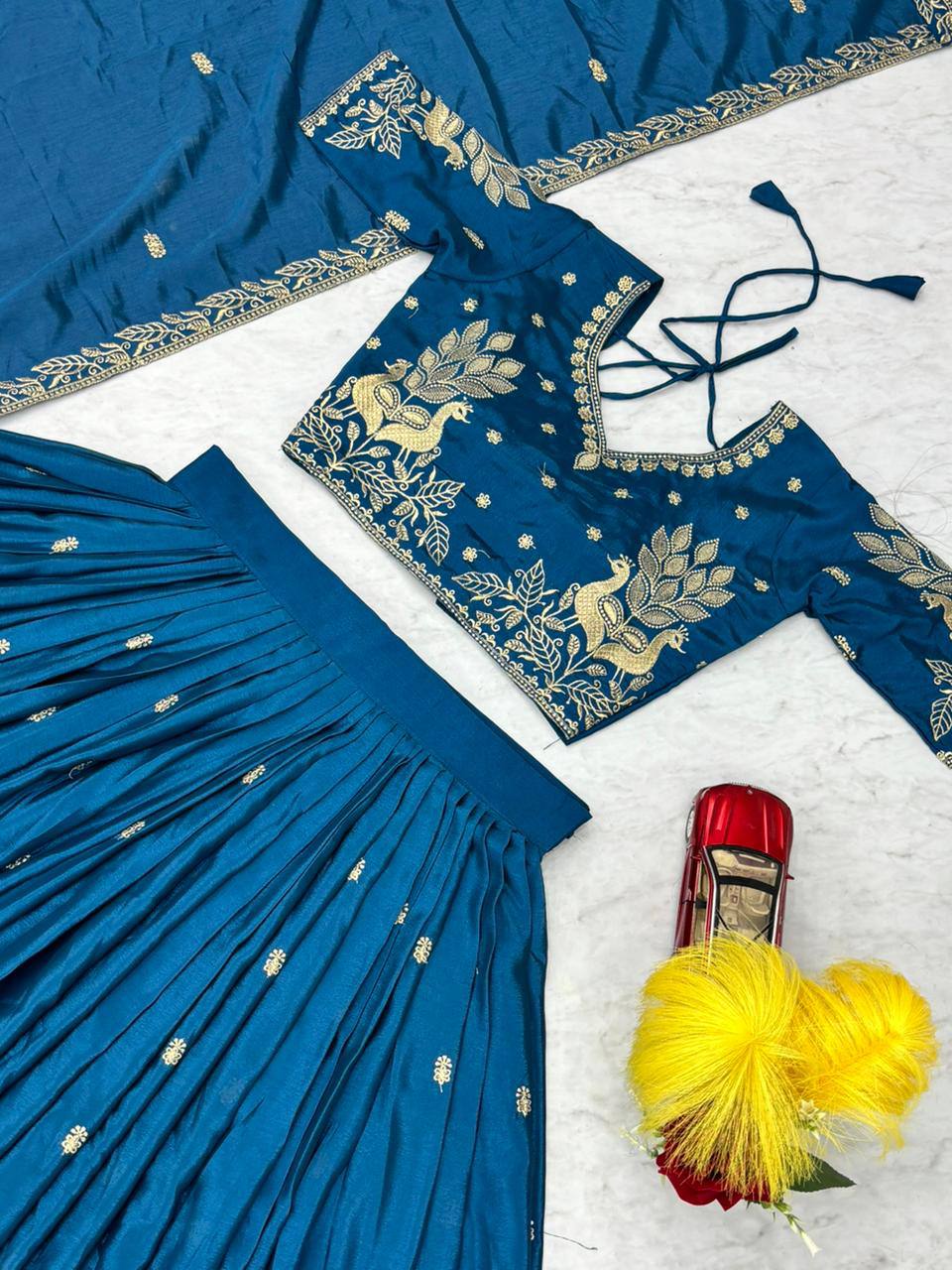Blue embroidered fabric with gold detailing on a white background