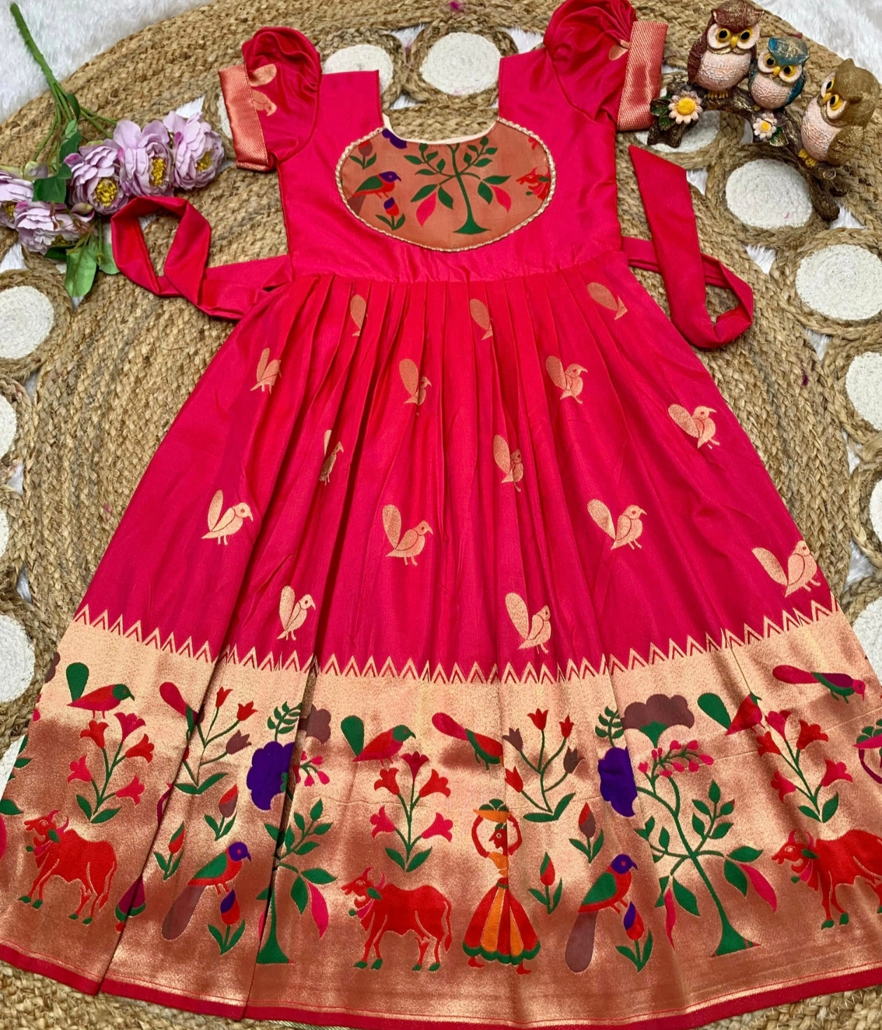 Red and embroidery dress on a texture surface with flowers and owls.