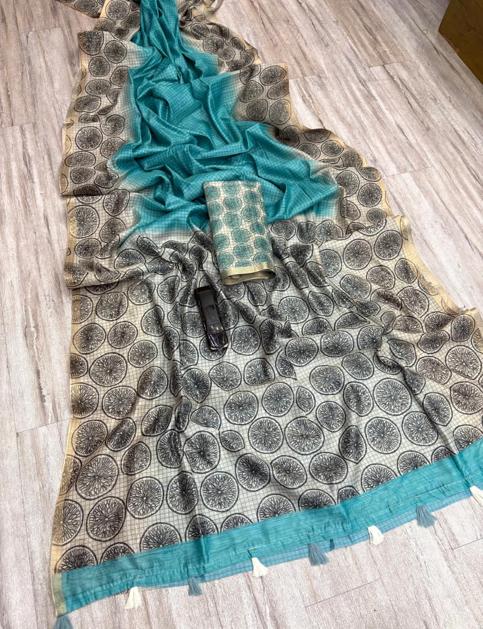 Patterned Sky Blue fabric with  trim on a wooden floor