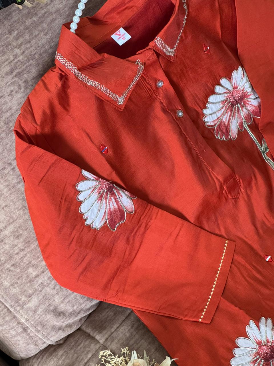 Orange garment with floral patterns on a textured surface