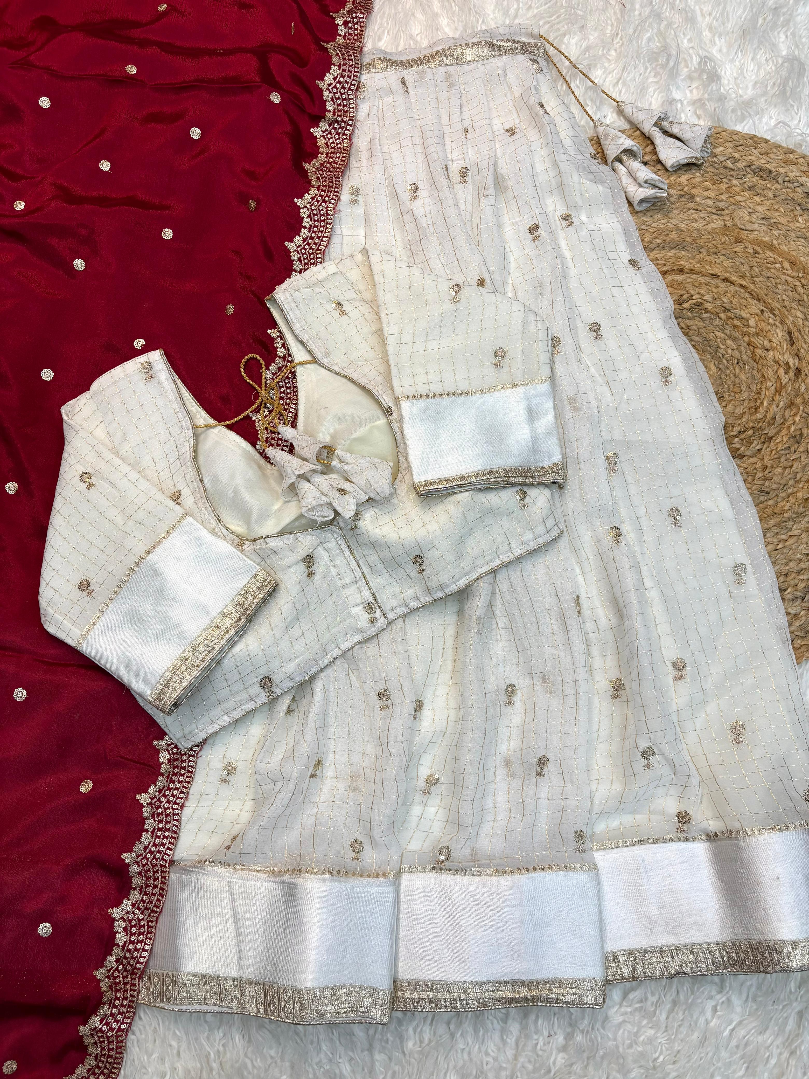 White embroidered saree with maroon border on a texture surface