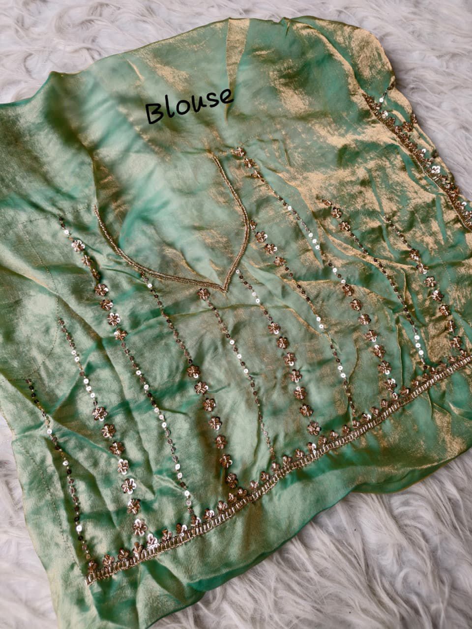 Light Green blouse with gold embroidery on a texture surface