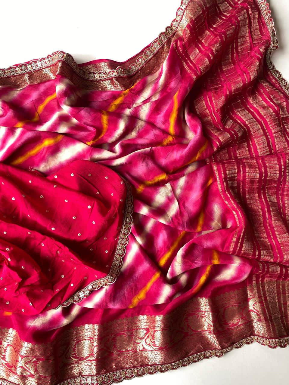 Pink saree with gold and white patterns on a white background