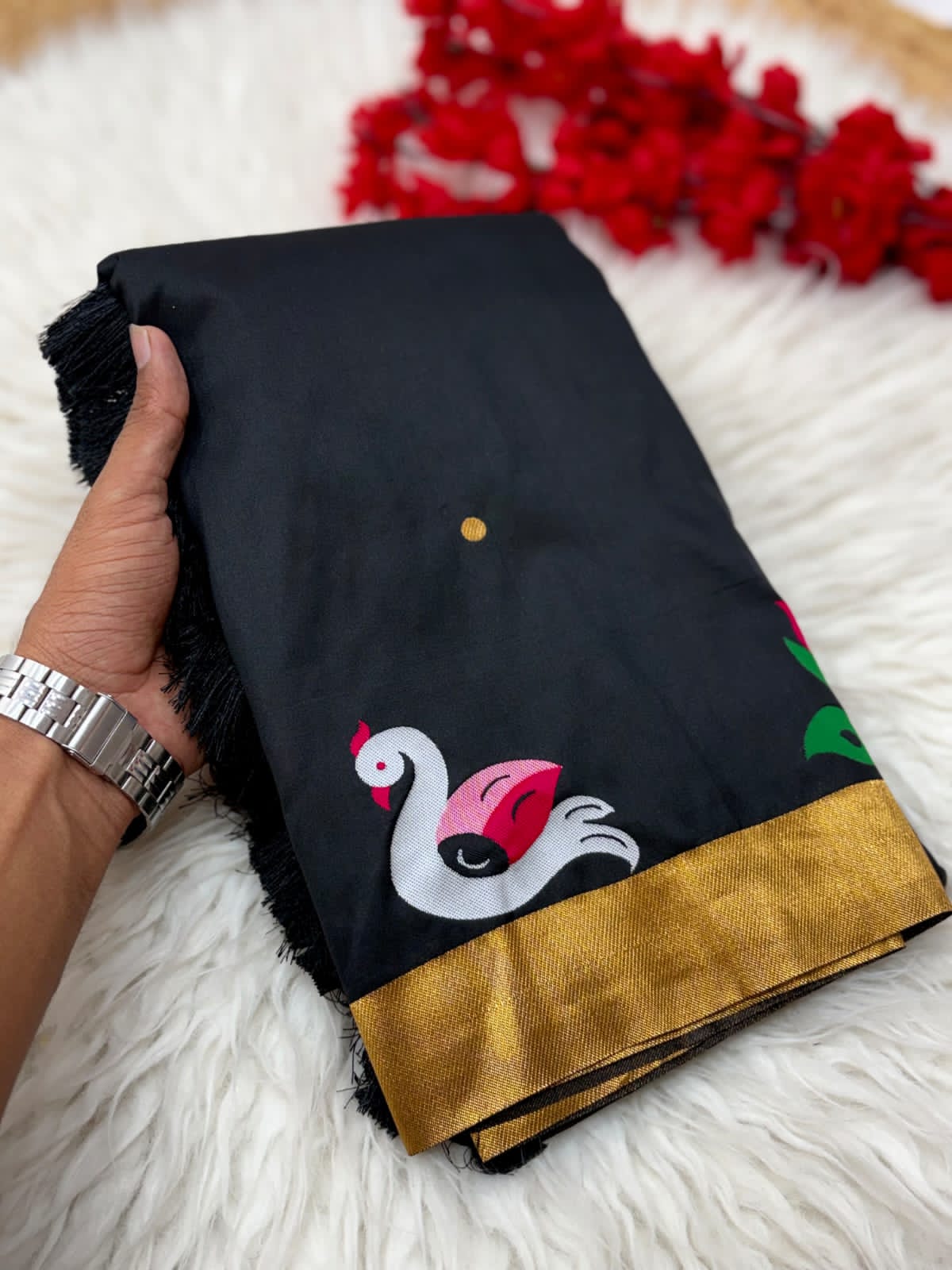Black fabric with swan design held by a hand on a  background