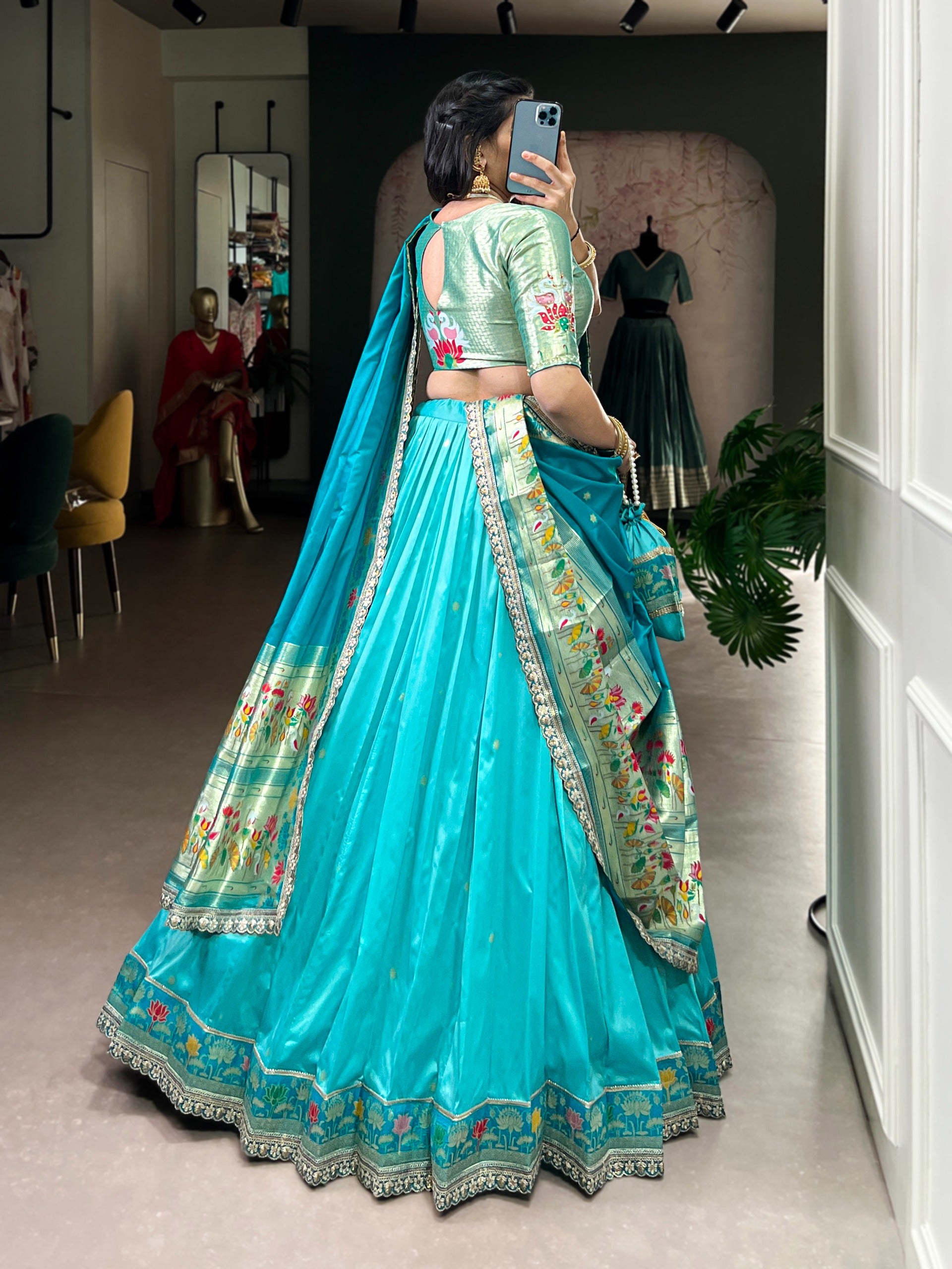 Woman in a sky Blue traditional outfit taking a mirror selfie.