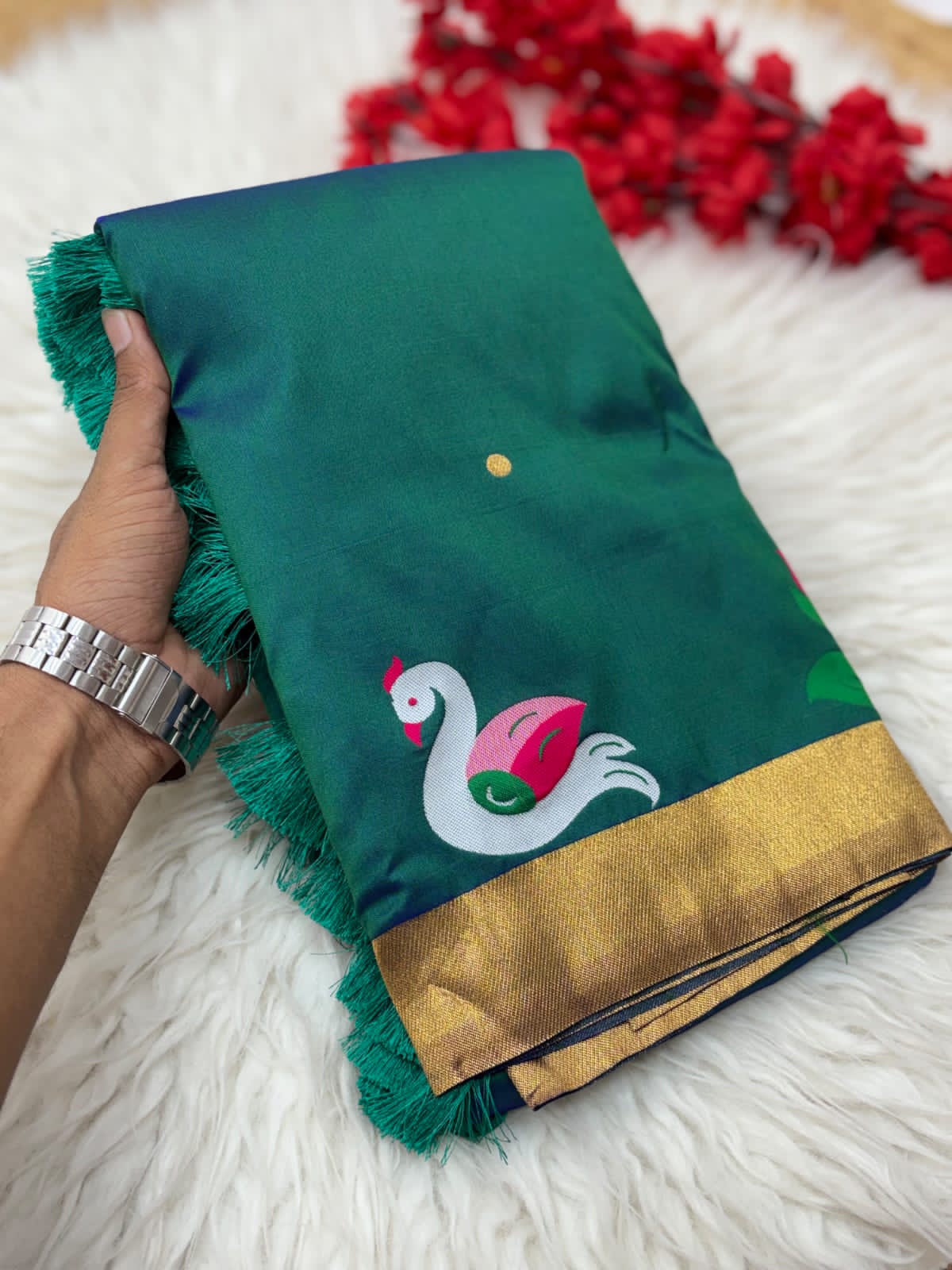 Rama Green saree with a swan design held by a hand on a  background