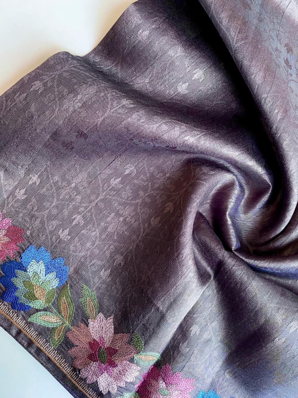 Gray fabric with floral embroidery on a white background