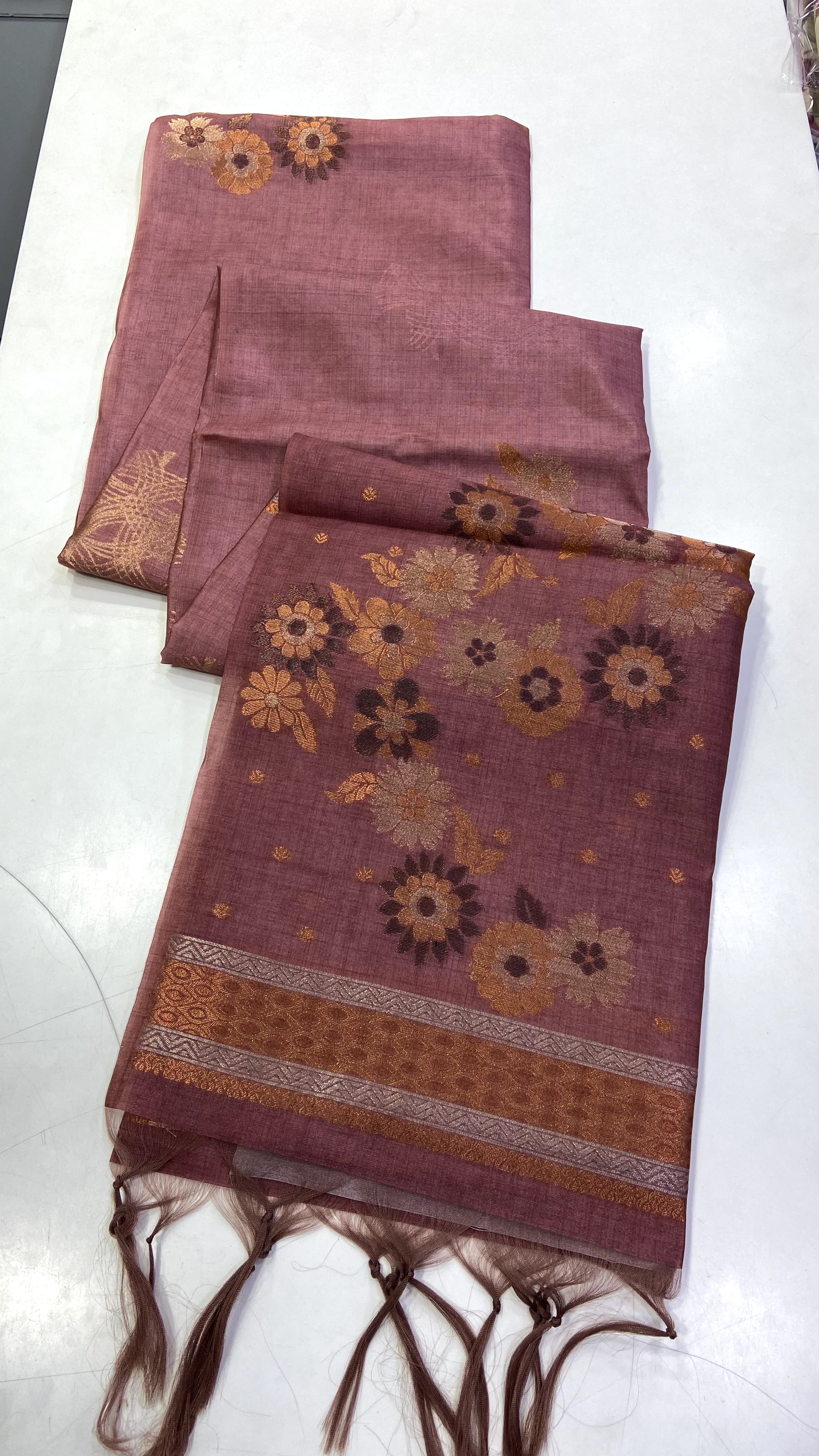 Copper saree with floral patterns on a white surface