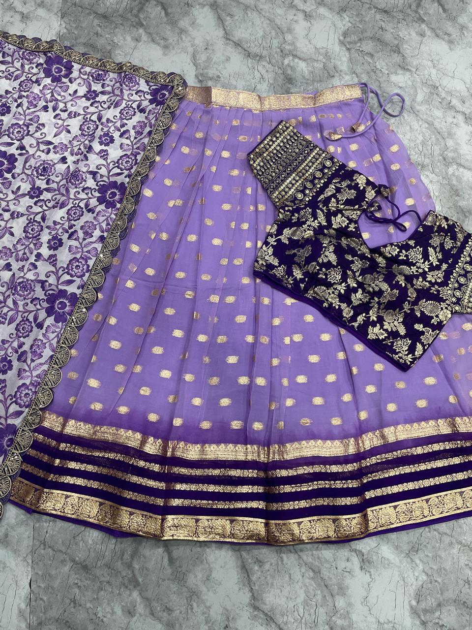 Purple saree with gold patterns on a gray surface